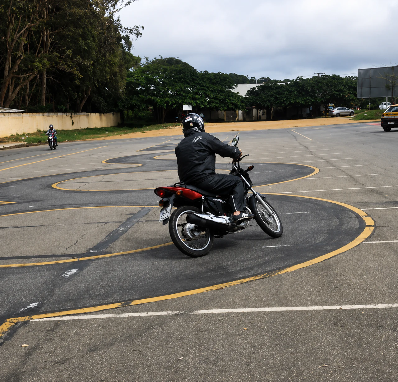 Motociclista realizando uma manobra no circuito da prova prática